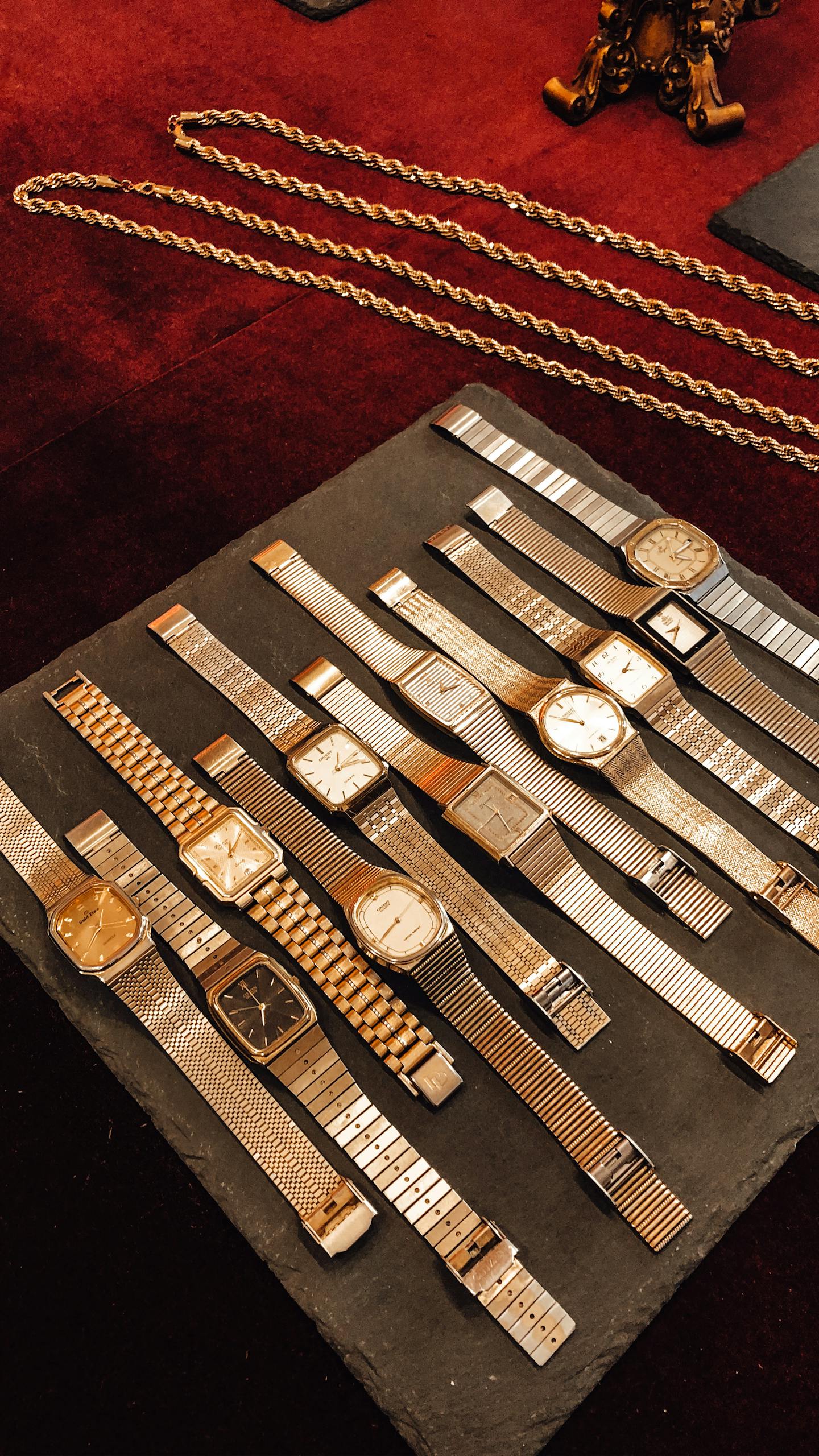 From above collection of vintage golden wrist watches placed on counter in shop